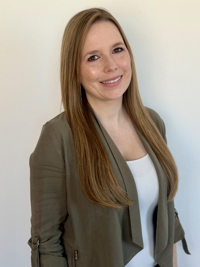 Katharina Murnberger-Maa lächelt in die Kamera. Sie hat lange, dunkelblonde Haare und trägt einen olivgrünen Blazer.